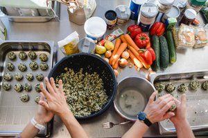 Gesunde Schulküche wird vorbereitet- man sieht zwei Hände beim kochen.