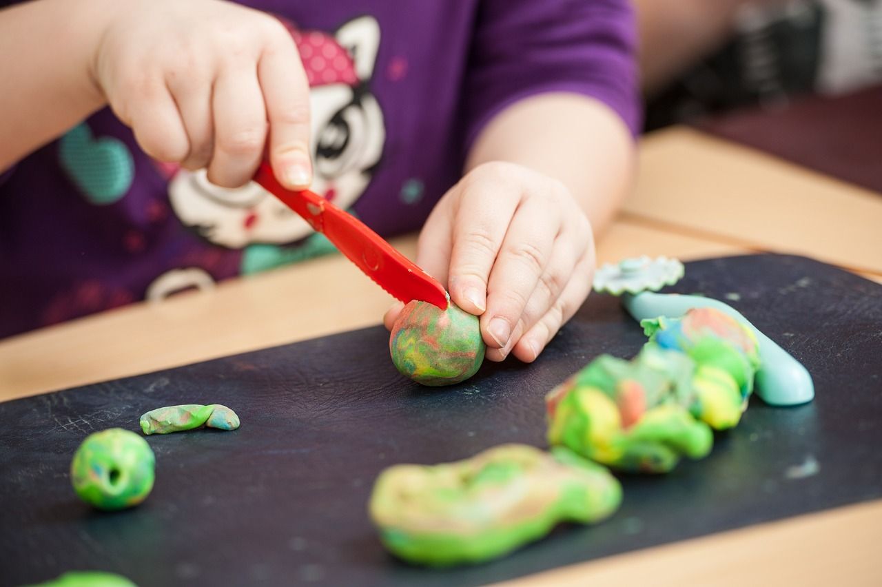 Kinderhände Spielen mit Plastelin