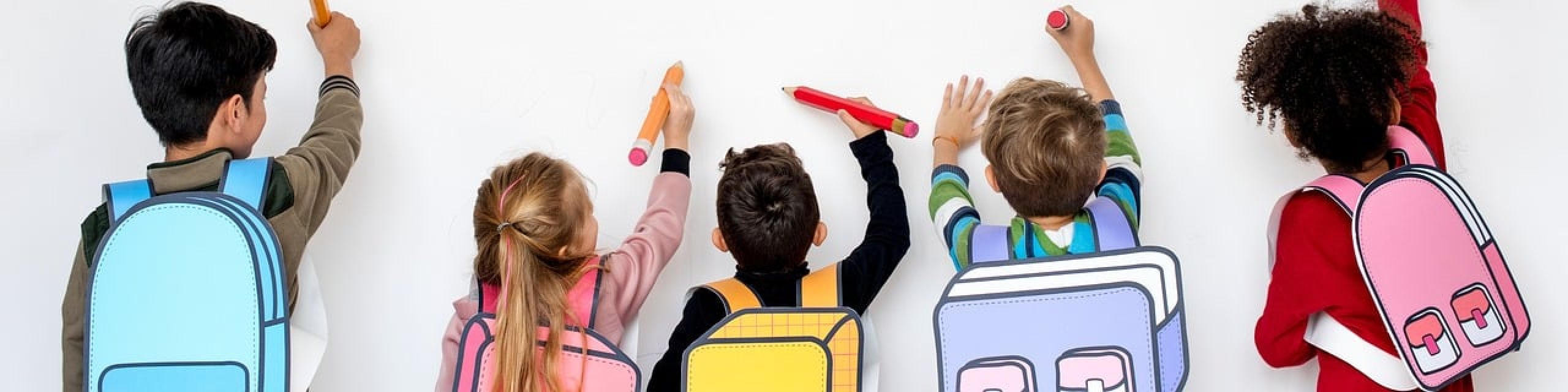 Kinder mit bunten Schultaschen malen auf eine Wand. - Imagebild