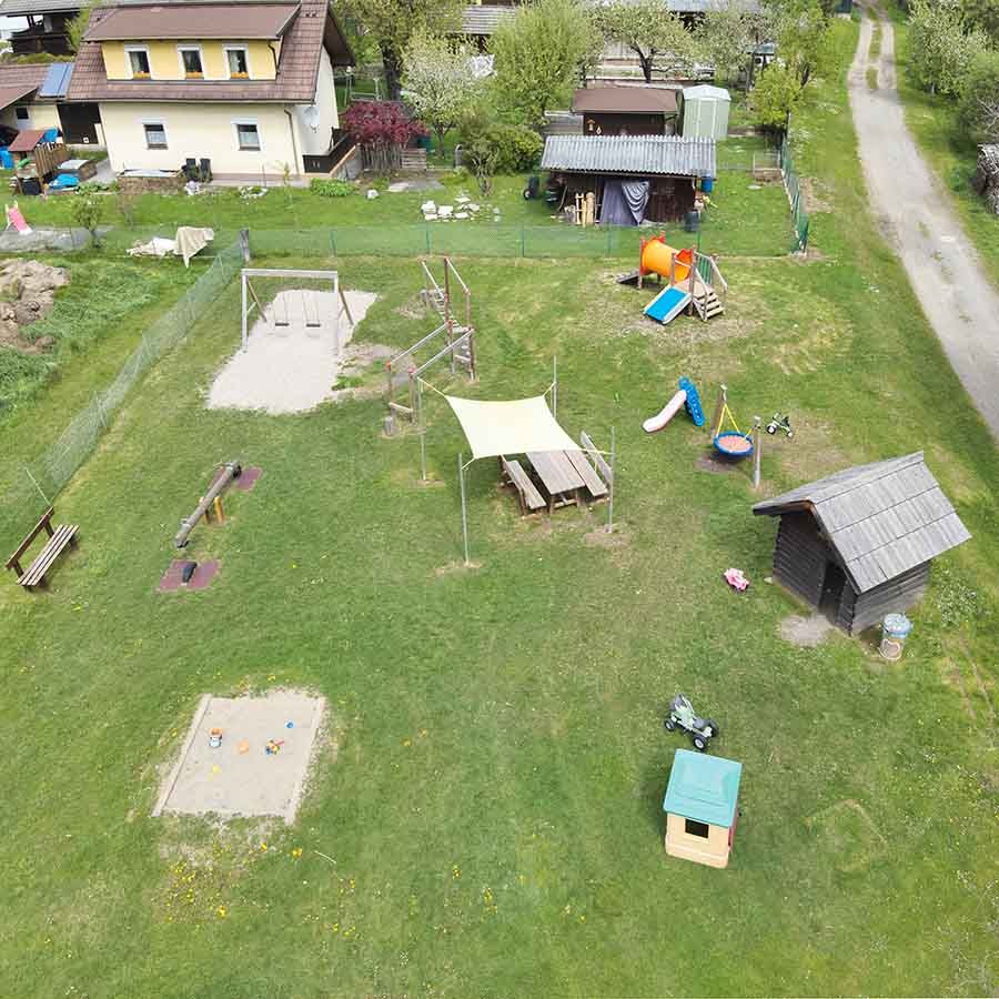 Der Speilplatz Lieserbrücke von der Luft aus, er bietet eine große Spielwiese mit Überdachung für die Eltern und einer Sitzgruppe. Eine Sandkiste eine Schaukel und eine Hutsche für Große und auch für kleine Kinder. 