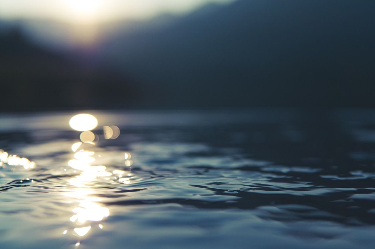 Ein Bild bei dem man einen Sonnenuntergang am Wasser sieht.  Symbolfoto