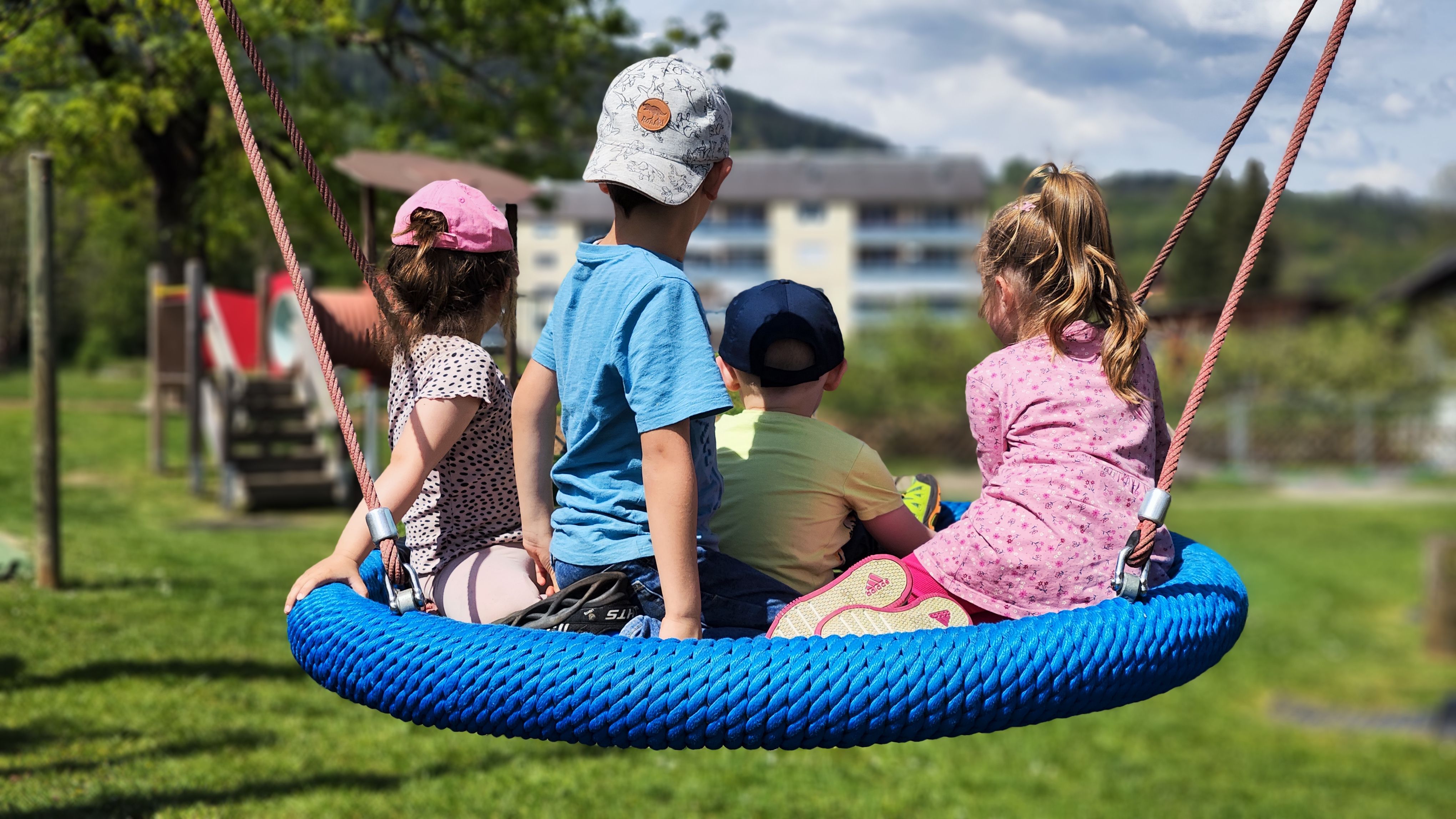 Kinder in einer Kinderschaukel - im Garten vom Kindergarten Lieserhofen