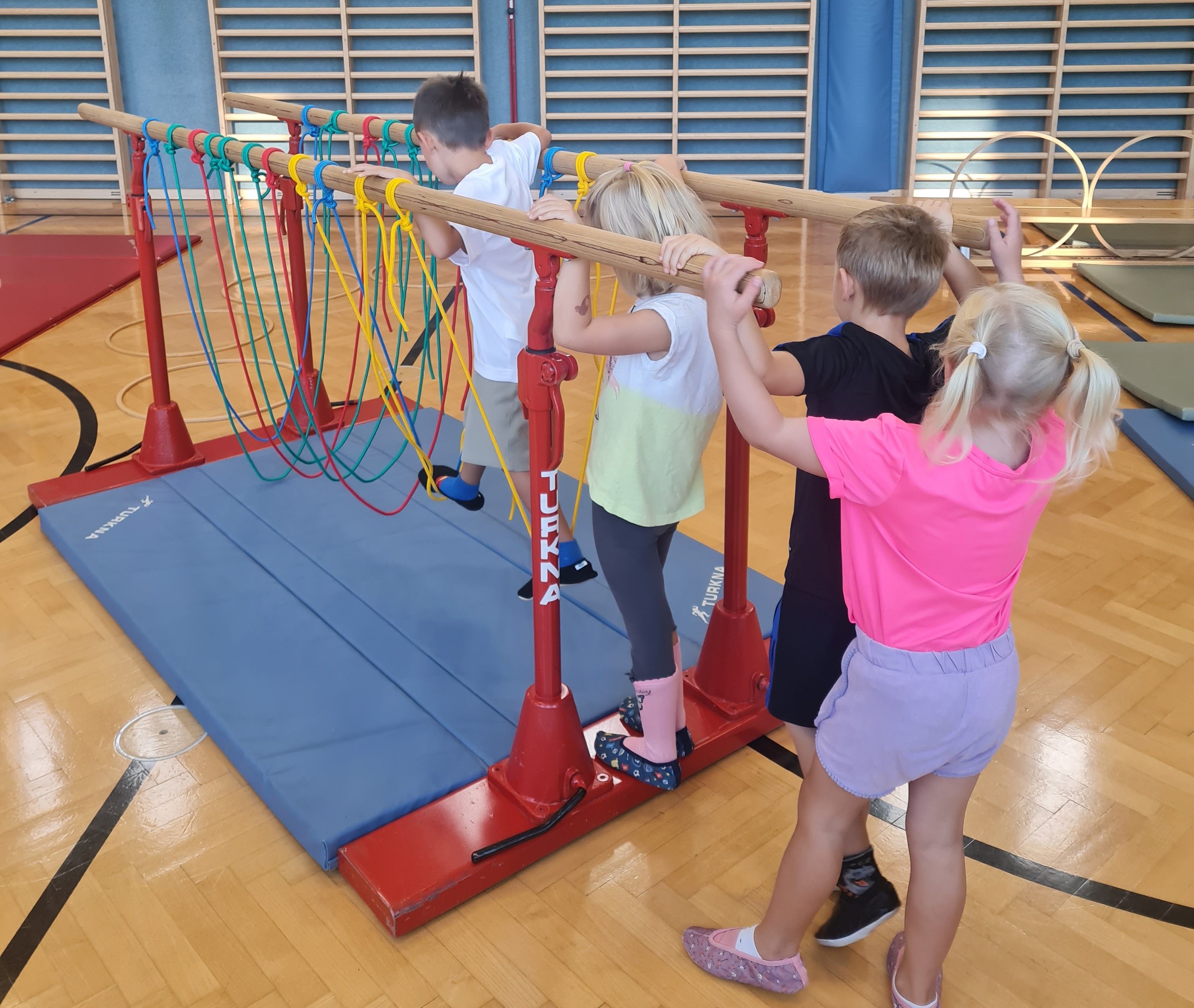 Die Kinder können den Turnsaal von der VS Treffling mitbenutzen,  auf dem Bild turnen 4 Kinder im Turnsaal. 